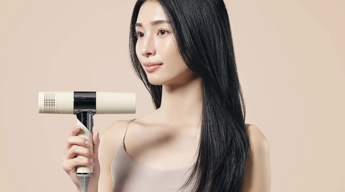 ホワイトのKINUJO Hair Dryerを手に持つモデル写真
